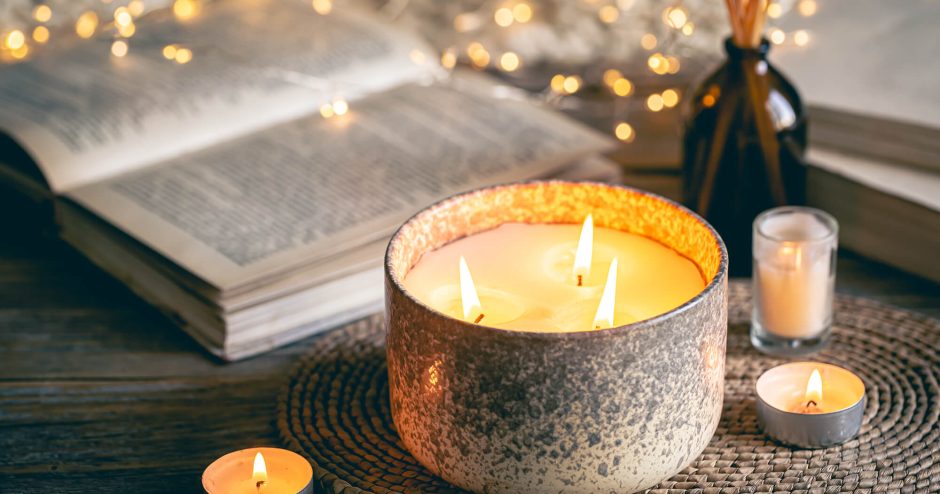 cozy-winter-composition-with-candles-blurred-background-with-books